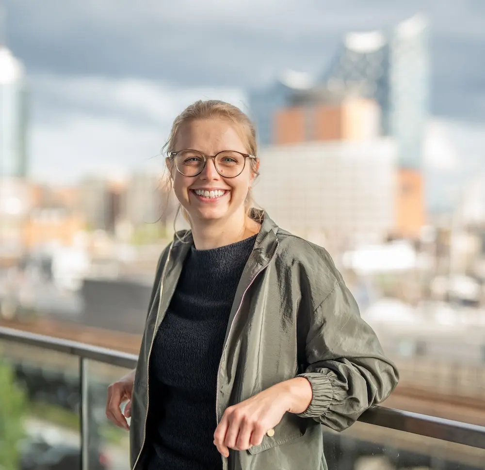 Anne Kritter lächelnd mit Elphi im Hintergrund