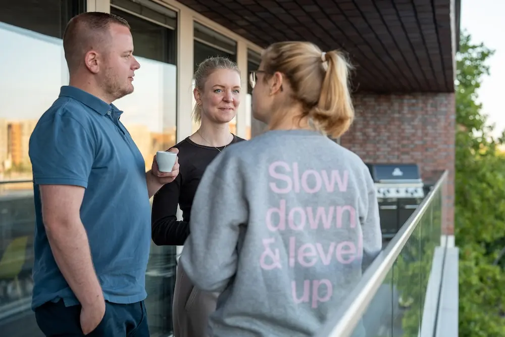 Anne mit zwei jungen Teilnehmern auf dem Balkon während der Pause eines Workshops zur Stressbewältigung in Hamburg